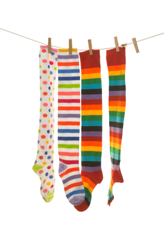 multi coloured striped socks hanging on the clothesline. Image isolated on white background
