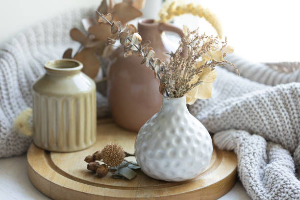 istock A cozy composition with dried flowers in a vase and a knitted element. 1700329054