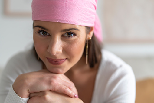 Beautiful woman posing with a pink veil on her head claiming the fight against cancer