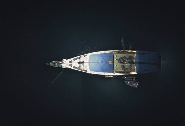istock a boat floats through the water at night, with one person aboard 1700337776