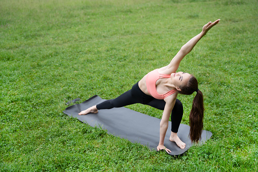 Young Asian woman doing morning exercises in the park energized by nature