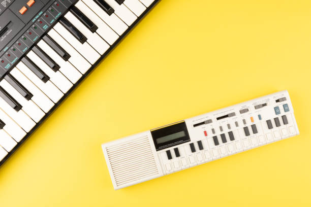 istock Vintage electronic keyboard synth piano on yellow background 1700344791