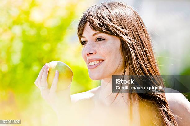 Felice Donna Che Mangia Una Mela In Un Parco Stile Di Vita Sano - Fotografie stock e altre immagini di Accudire