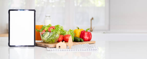 istock Digital tablet computer with mockup white screen on vegetarian healthy food vegetable background. Online grocery shopping delivery app ads concept, cook book diet plan nutrition recipes, close up view 1700353206