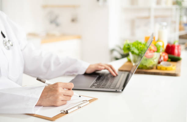 istock Female nutritionist doctor writing vegetable diet plan 1700357082