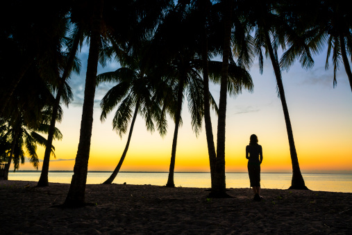 Woman waiting for a sunrise on a beach on Cuban coast.