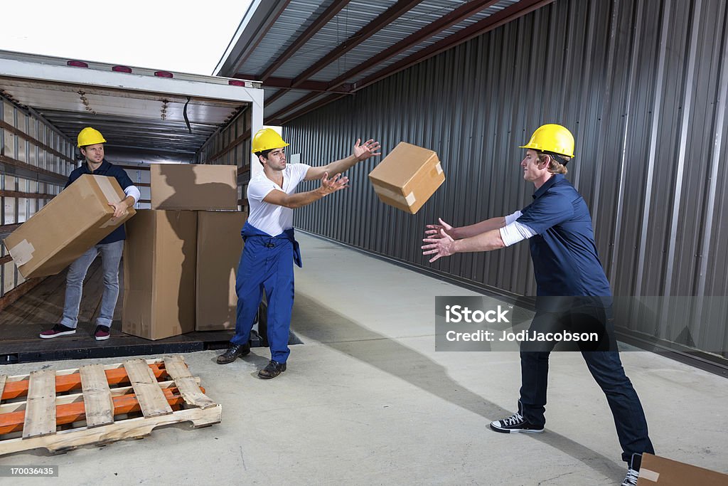 I dipendenti della società lanciare scatole di spedizione - Foto stock royalty-free di Lanciare