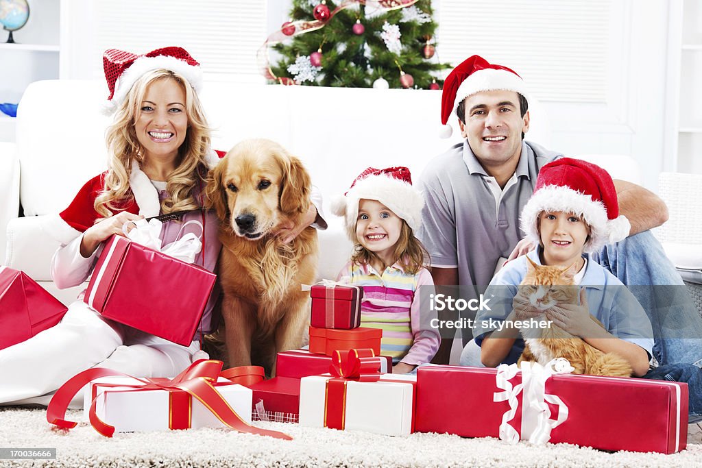 Giovane famiglia godendo di Natale con gli animali domestici - Foto stock royalty-free di Natale