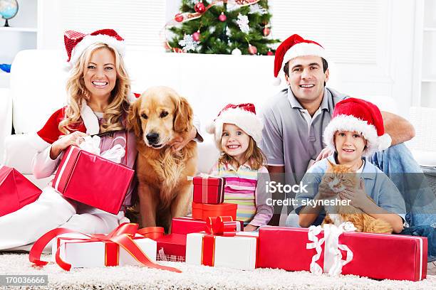 Молодая Семья Наслаждаясь В Рождество С Домашними Животными — стоковые фотографии и другие картинки Рождество