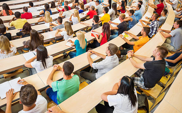 vista posteriore di grande gruppo di studenti in università anfiteatro. - anfiteatro foto e immagini stock