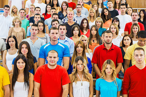 Group of serious college students in the university amphitheatre, they are standing and looking at camera.   