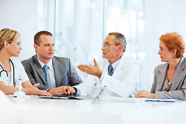 los médicos colaborar con el equipo de negocios. - exam business caucasian board room fotografías e imágenes de stock