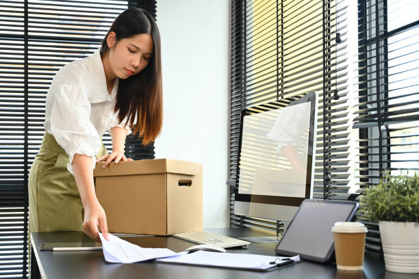 istock A female office worker is packing things on her desk. After being fired from a job or quitting a job 1700373017