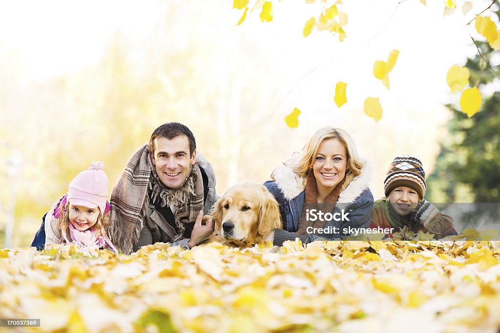 Семья из четырех человек с их Собака в парке. - Стоковые фото Благополучие роялти-фри