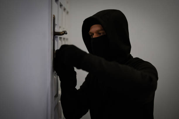 istock Thief opening door with lock picker. 1700375908