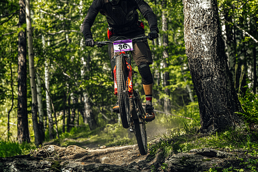 athlete mountainbiker downhill forest trail, racing DH mountain bike, extreme sport games