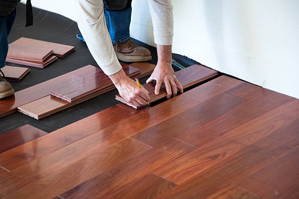 Installing Hardwood Floor A worker installing hardwood floor in an American upscale home.A worker installing hardwood floor in an American upscale home. mahogany photos stock pictures, royalty-free photos & images