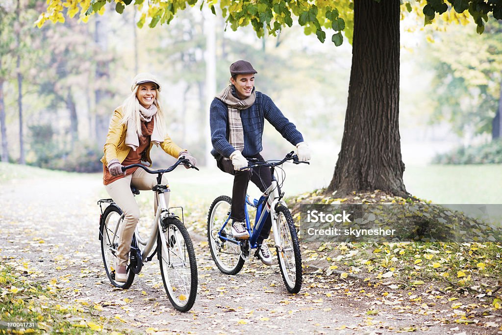 Yong par de paseos, bicicletas en un hermoso día de otoño - Foto de stock de Andar en bicicleta libre de derechos