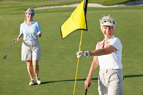 Senior woman playing golf with her friends.