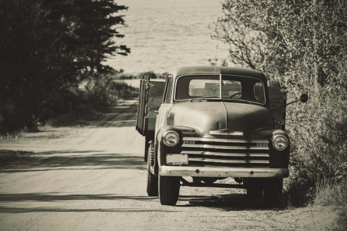 A late 1940's farm truck on a narrow country road near the Bay of Fundy.  Toned black and white.