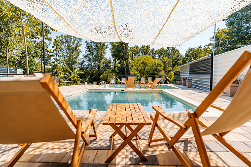 Outdoor swimming pool with lounge chairs in the backyard.