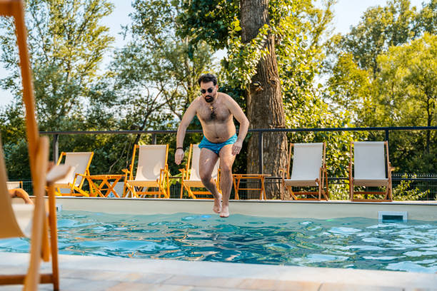 istock Young Man Jumping In The Backyard Swimming Pool 1700434863