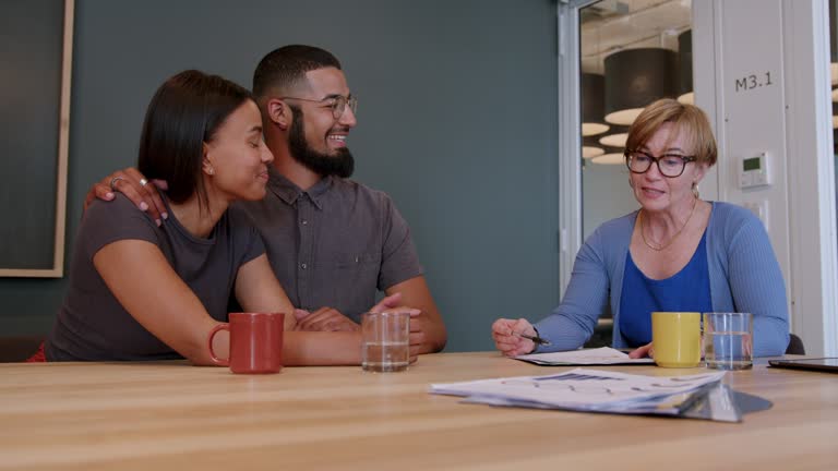 Smiling young couple meeting with their financial advisor in her office