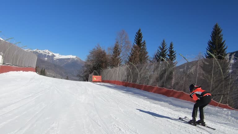 Tracking shot of an Adult woman skiing on a slope