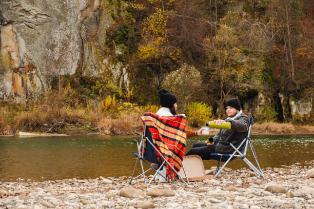 istock happy couple having picnic at river beach 1700449034