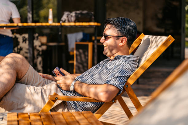 istock Young Man Relaxing On The Lounge Chair In The Backyard 1700450671