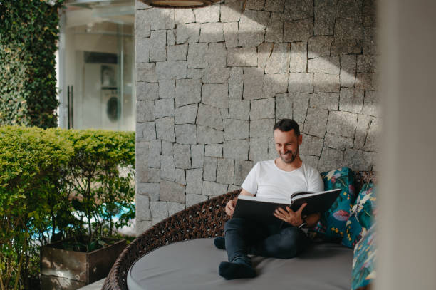 istock Man enjoying a book in his backyard 1700452953