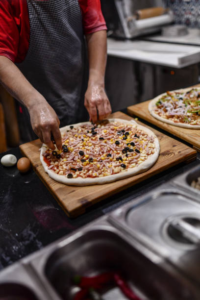 istock Chef Ordering Ingredients On Pizza Dough In Restaurant 1700453477