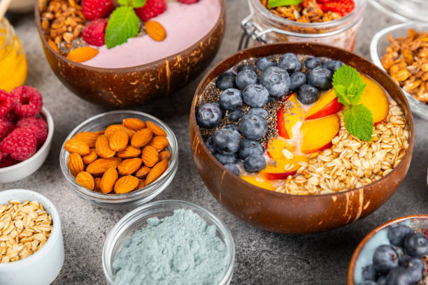 istock Useful breakfast. Granola bowl with yogurt and fresh berries on a textured kitchen table.Acai and spirulina bowl.Bowl of Greek yogurt with granola, almonds, blueberries, raspberries and strawberries. 1700457067