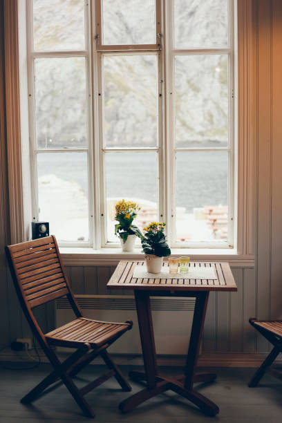 istock Empty table and antique wooden chairs near a window 1700465327