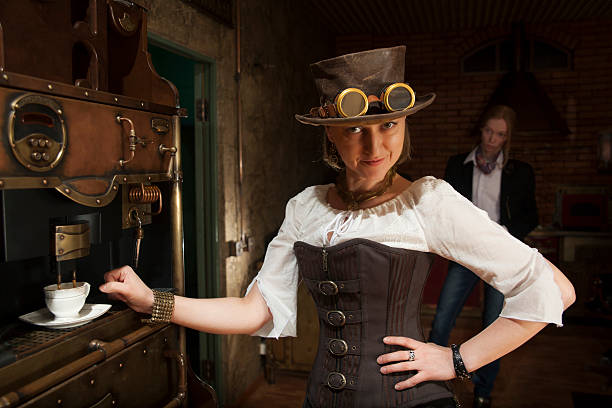 Young woman and man in steampunk stile make a coffee Young woman in steampunk style clothing is making coffee with coffee machine which also has the steampunk theme. The woman has a smirk on her face and one hand on her while reaching for the cup with her other hand. There is a woman behind her looking at her and has a white shirt, a blazer, and jeans on. They seem to be in an old timey kitchen.  steampunk fashion stock pictures, royalty-free photos & images