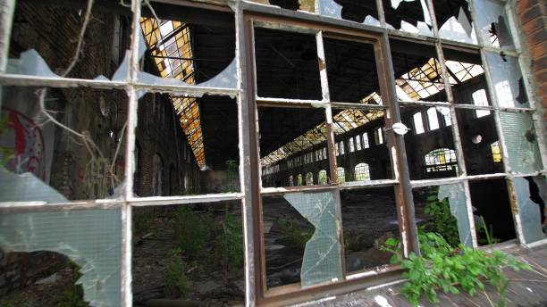 istock Broken Windows in Abandoned Industrial Warehouse Factory Brick Building 1700466929