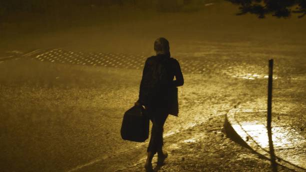 istock Lonely Person Walking in Heavy Rain with Lightnings at Night 1700467479