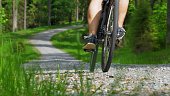 Cyclist Riding Bicycle on Gravel Road in Forest Slow Motion