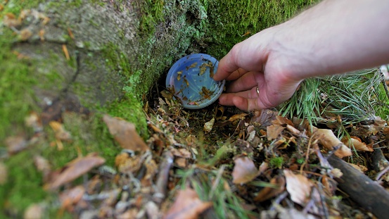 Playing Treasure Hunt Game Hiding and Finding Geocache Container in Forest POV