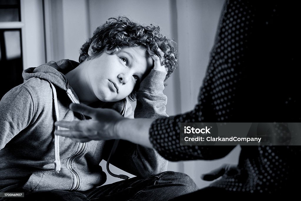 Parenting Eleven year old boy talking to a parent,guardian or social worker. Toned black and white. Child Stock Photo