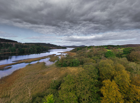 High angle view from a drone of a loch in rural Scotland on an overcast Autumn morning