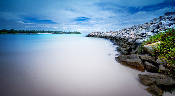 Long exposure shot along the breakwaters that are dotted along the shoreline of Reethi Rah Island, Maldives.