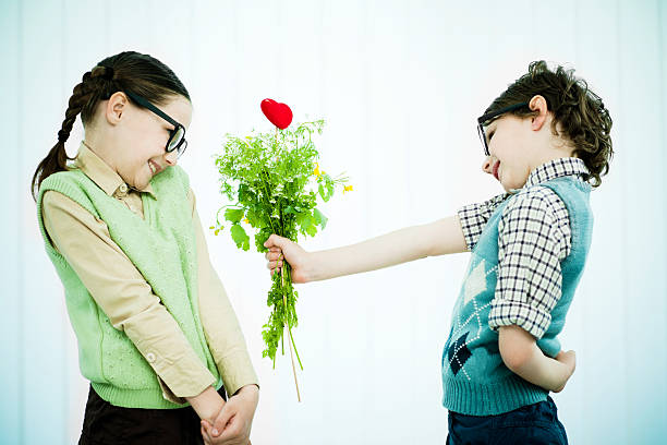 carino geek ragazzo dando la sua ragazza un regalo di san valentino. - valentines day love nerd couple foto e immagini stock