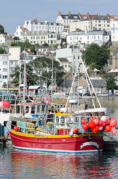 Trawler in harbor of St. Peter Port on Guernsey Red trawler in harbor of St. Peter Port on channel island Guernsey. guernsey city stock pictures, royalty-free photos & images