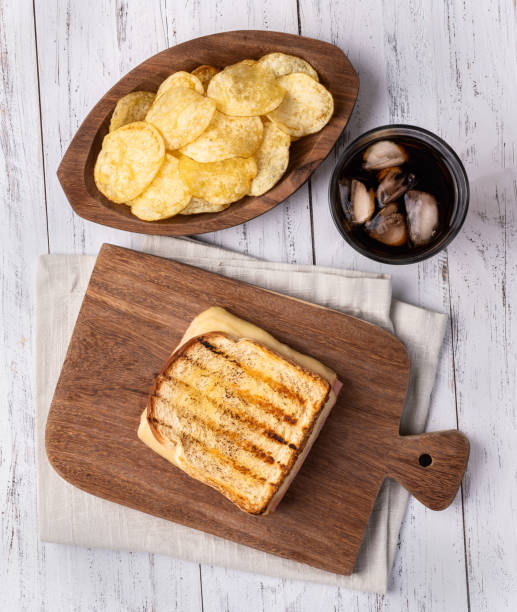 istock Cheese and ham sandwich with potato chips and soda 1700488527