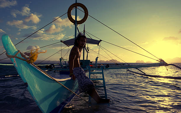 philippino с его традиционным banca аутригер лодки на филиппинах - nautical vessel philippines mindanao palawan стоковые фото и изображения