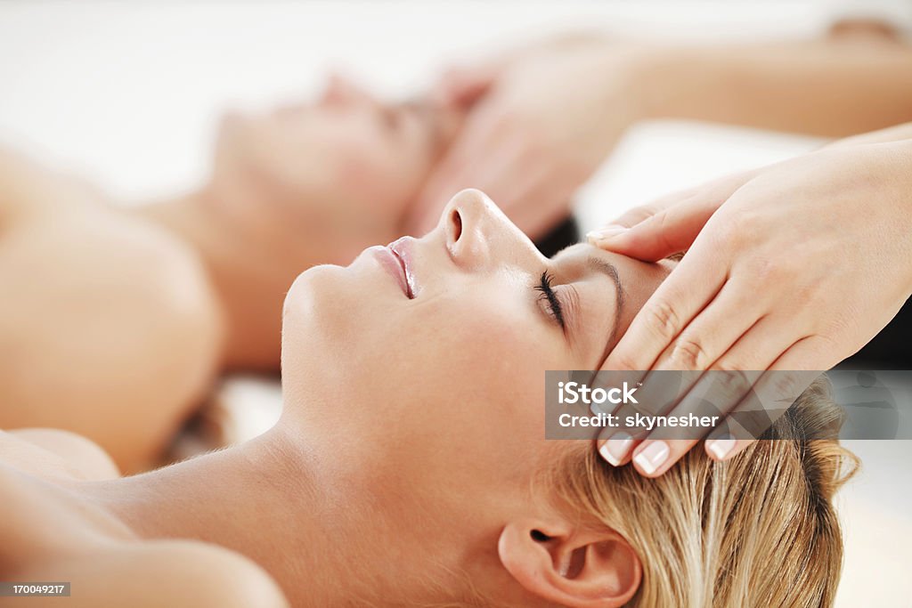 Young couple is having a head massage at spa centre. A romantic couple is enjoying in the spa treatment at the spa centre.   Essential Oil Stock Photo