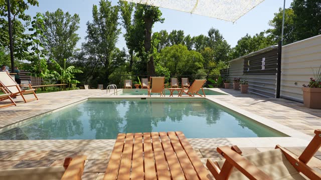 Outdoor Swimming Pool With Lounge Chairs In The Backyard