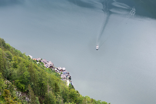 Hallstatt, Austria, July 9, 2022: A motorboat sails on the lake Hallstätter See in Upper Austria. The lake is situated in the Salzkammergut region part of which is listed as UNESCO World Heritage Site.