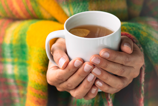 Woman holding a cup of tea.